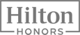 The image is a logo featuring the words "Hilton Honors" in a gray, uppercase font within a rectangular frame.