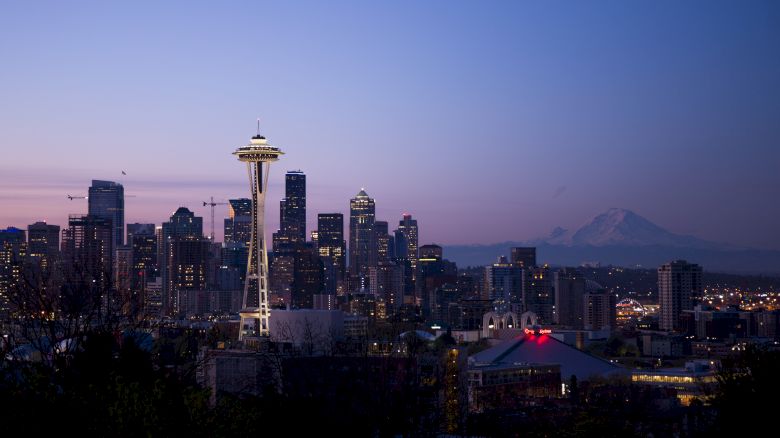 Seattle skyline at dusk with the Space Needle and Mount Rainier in the background.